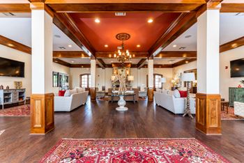 Resident clubhouse with ample seating, fire place, and TV at Riverstone apartments for rent